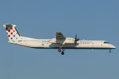 Airplane flying against clear blue sky