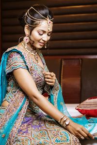 Bride in traditional clothing sitting on bed