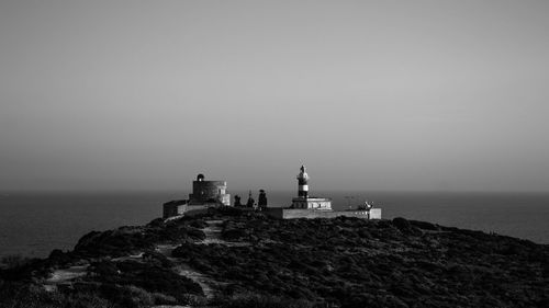 Lighthouse by sea against sky