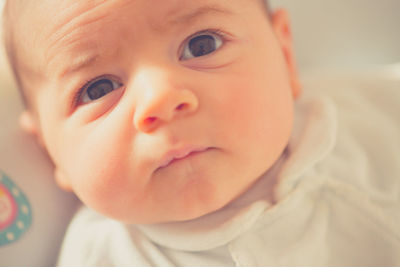 Close-up portrait of cute baby boy on bed