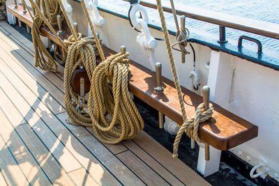 Ropes tied up on wooden seat in sailing ship