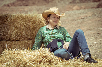 Full length of woman sitting in farm
