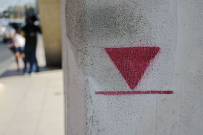 Close-up of arrow sign on wall