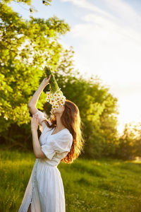 Rear view of woman standing against trees