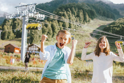 Portrait of happy siblings standing outdoors