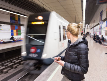 Woman standing on railroad station platform