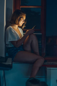 Young woman using mobile phone at home