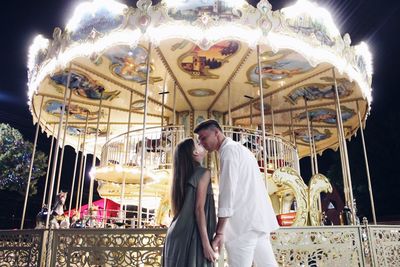 People in carousel at amusement park