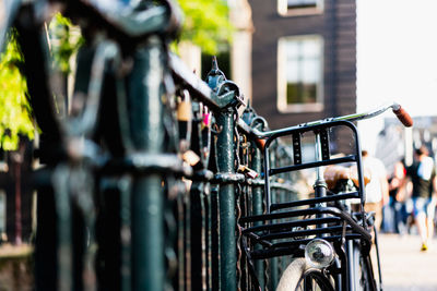 Close-up of bicycle parked by railing