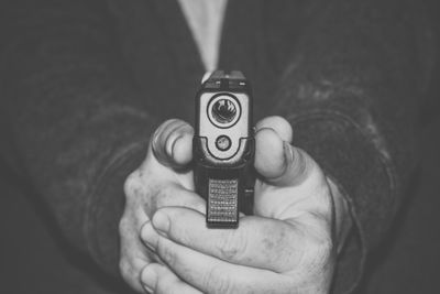 Midsection of man pointing gun