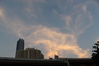 Low angle view of buildings against cloudy sky