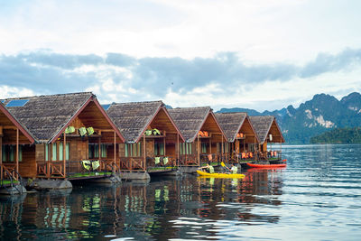 Houses by lake against sky