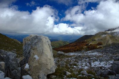 Scenic view of rocky mountains against cloudy sky