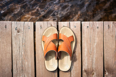 Leather sandals on a wooden path to the sea