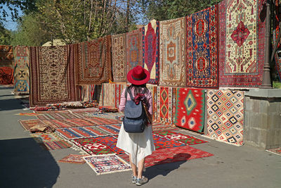 Female traveler impressed by the stunning carpets at vernissage market in downtown yerevan, armenia