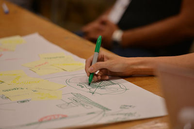 Cropped hand of woman drawing on paper