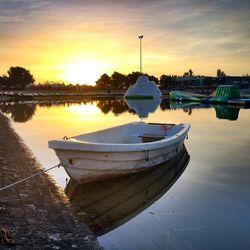 Boats in sea at sunset