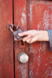 Cropped hand holding door padlock