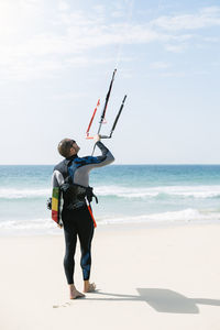 Full length of man holding umbrella on beach