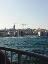 View of sea and buildings against clear sky