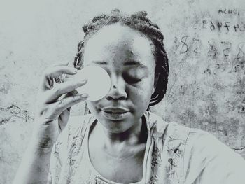 Portrait of a smiling young woman holding camera