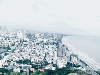 High angle view of cityscape by sea against sky