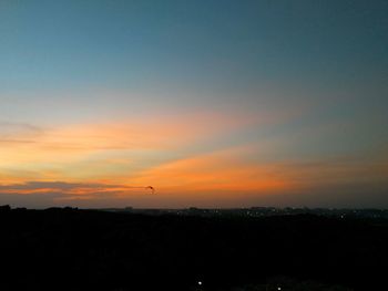 Silhouette landscape against sky at sunset