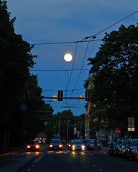 Illuminated street light against sky