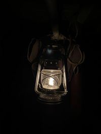 Close-up of illuminated light bulb against black background