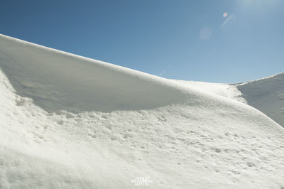 Scenic view of snowcapped mountains against clear blue sky