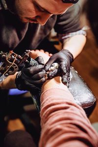 Man tattooing hand