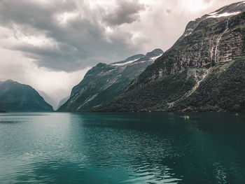 Scenic view of lake by mountains against sky