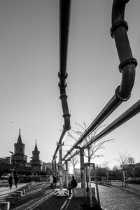 Men sculpture in city against sky