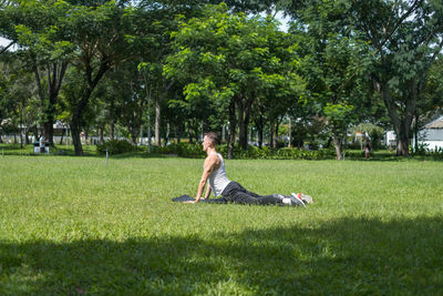 Sporty active young man in sportswear doing sport exercises in the park. fit caucasian man stretchin