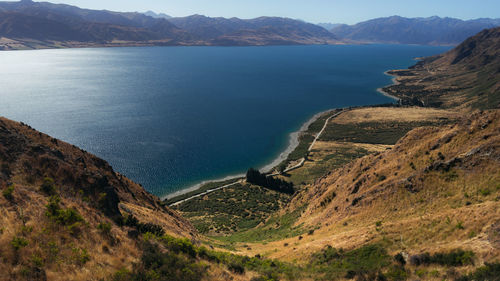 High angle view of sea and mountains against sky