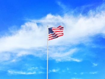 Low angle view of american flag against blue sky