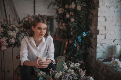 Portrait of beautiful woman with red flowers