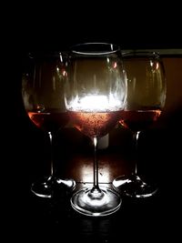 Close-up of wine glass on table against black background