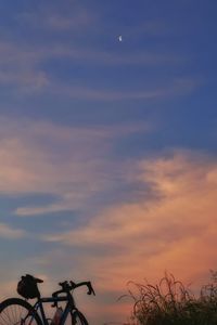 Silhouette of bicycle against cloudy sky