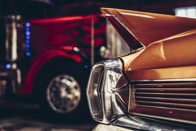 Close-up of vintage car tail fin with truck cab in background 