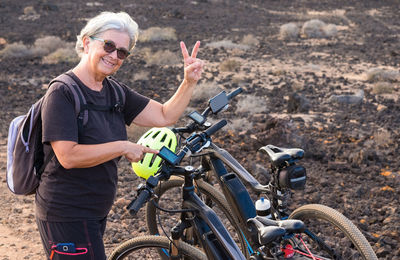 Portrait of smiling senior woman by bicycle