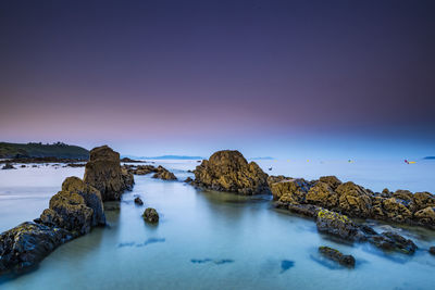 Scenic view of rocks in sea against sky