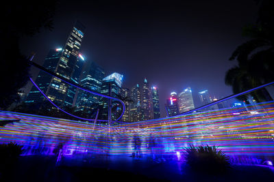 Illuminated modern buildings against sky at night