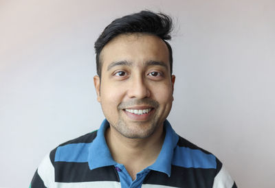 Portrait of smiling young man against white background