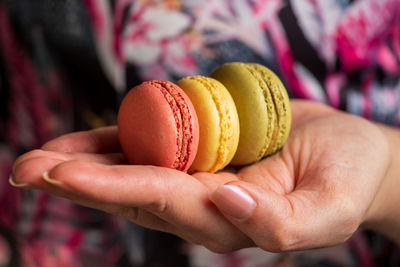 Close-up of hand holding macarons