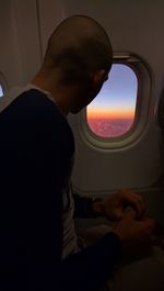 Midsection of man sitting in airplane window