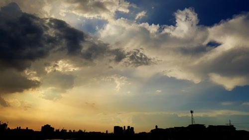 Low angle view of silhouette buildings against sky at sunset