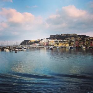 Scenic view of sea by town against sky