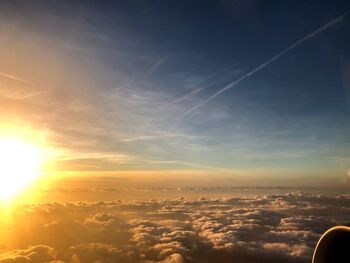 Aerial view of vapor trails in sky during sunset