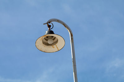 Low angle view of street light against cloudy sky